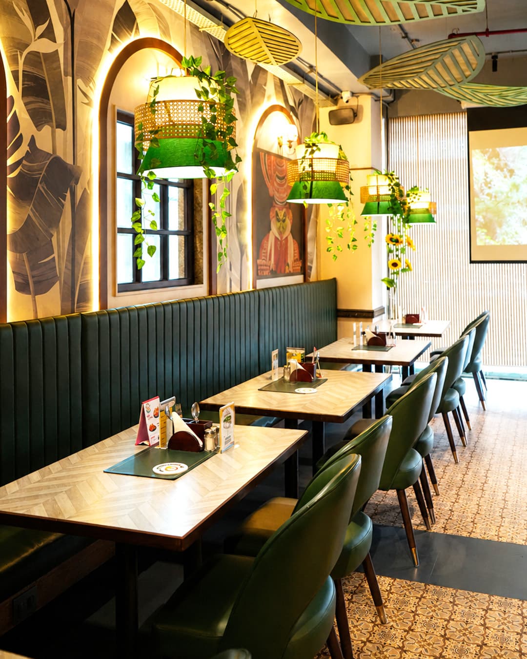 Kerala Table dining hall — green booth seating with warm ambient lighting